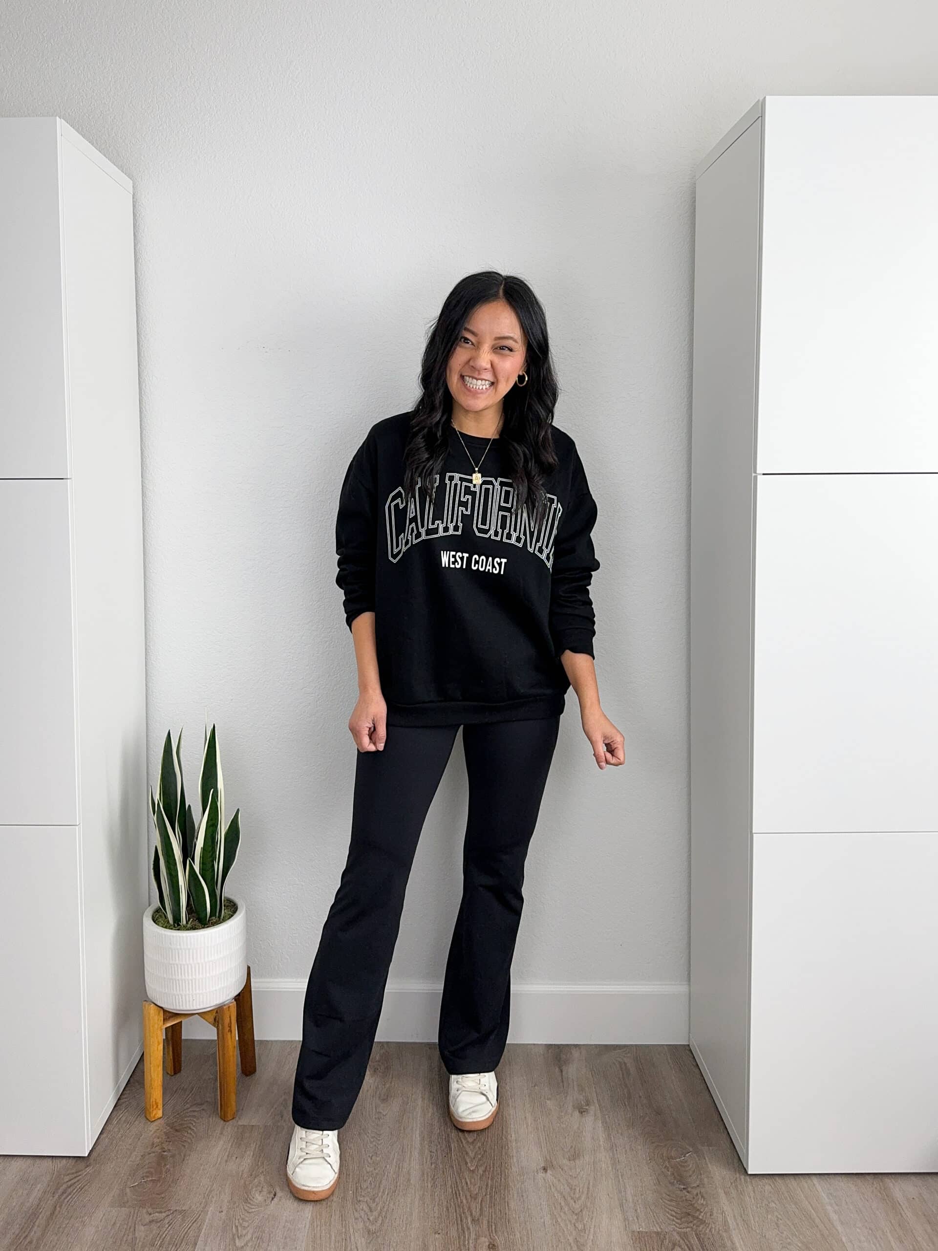 black sweatshirt + black fleece lined flare yoga pants + white sneakers + gold earrings + gold necklace black graphic sweatshirt + black fleece lined flare leggings + white sneakers + gold earrings + gold necklace