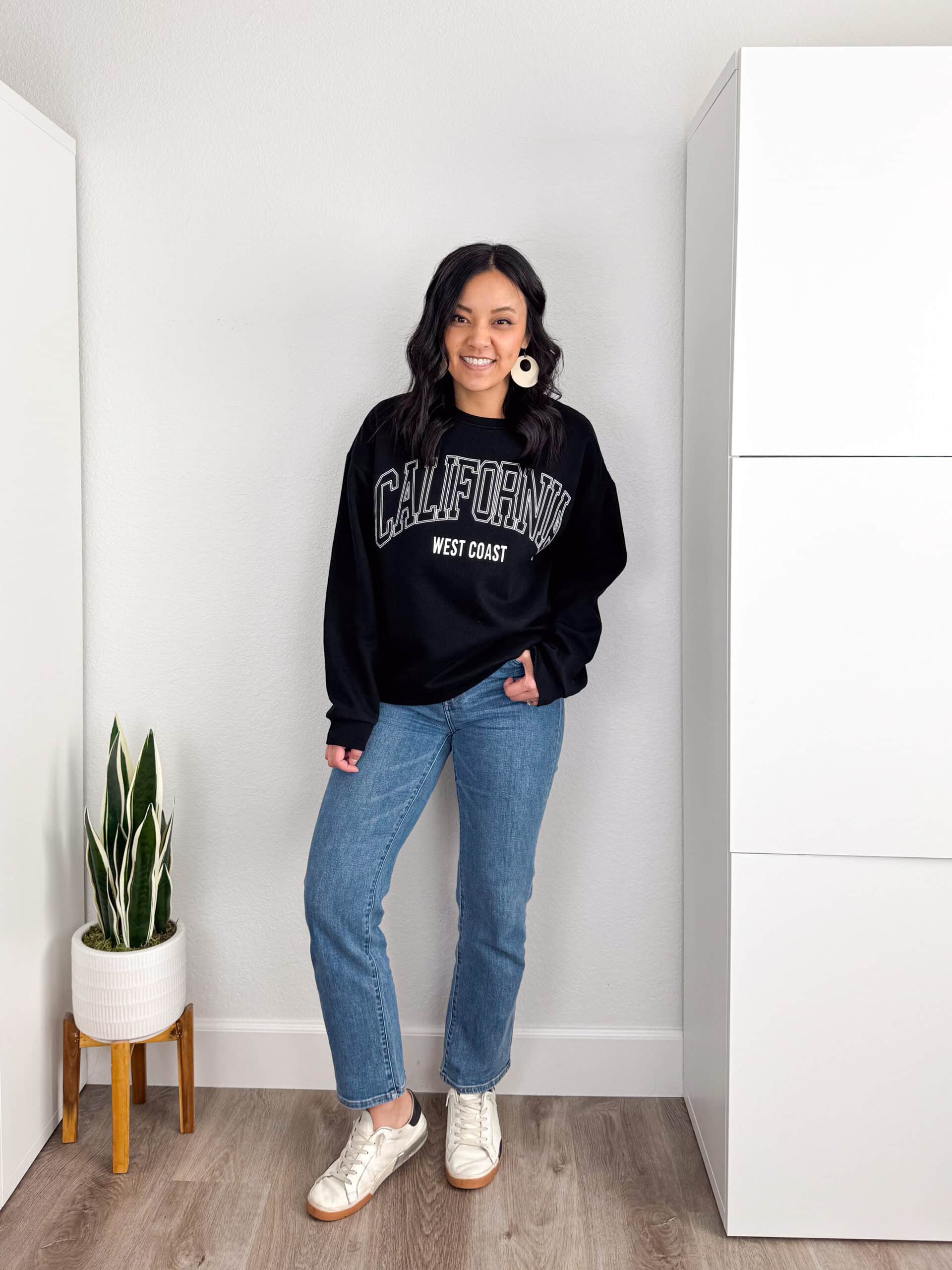 putting me together + black sweatshirt + straight leg medium wash jeans + white sneakers + white statement hoop earrings putting me together + casual graphic print sweatshirt + straight leg medium wash jeans + white sneakers + white statement hoop earrings