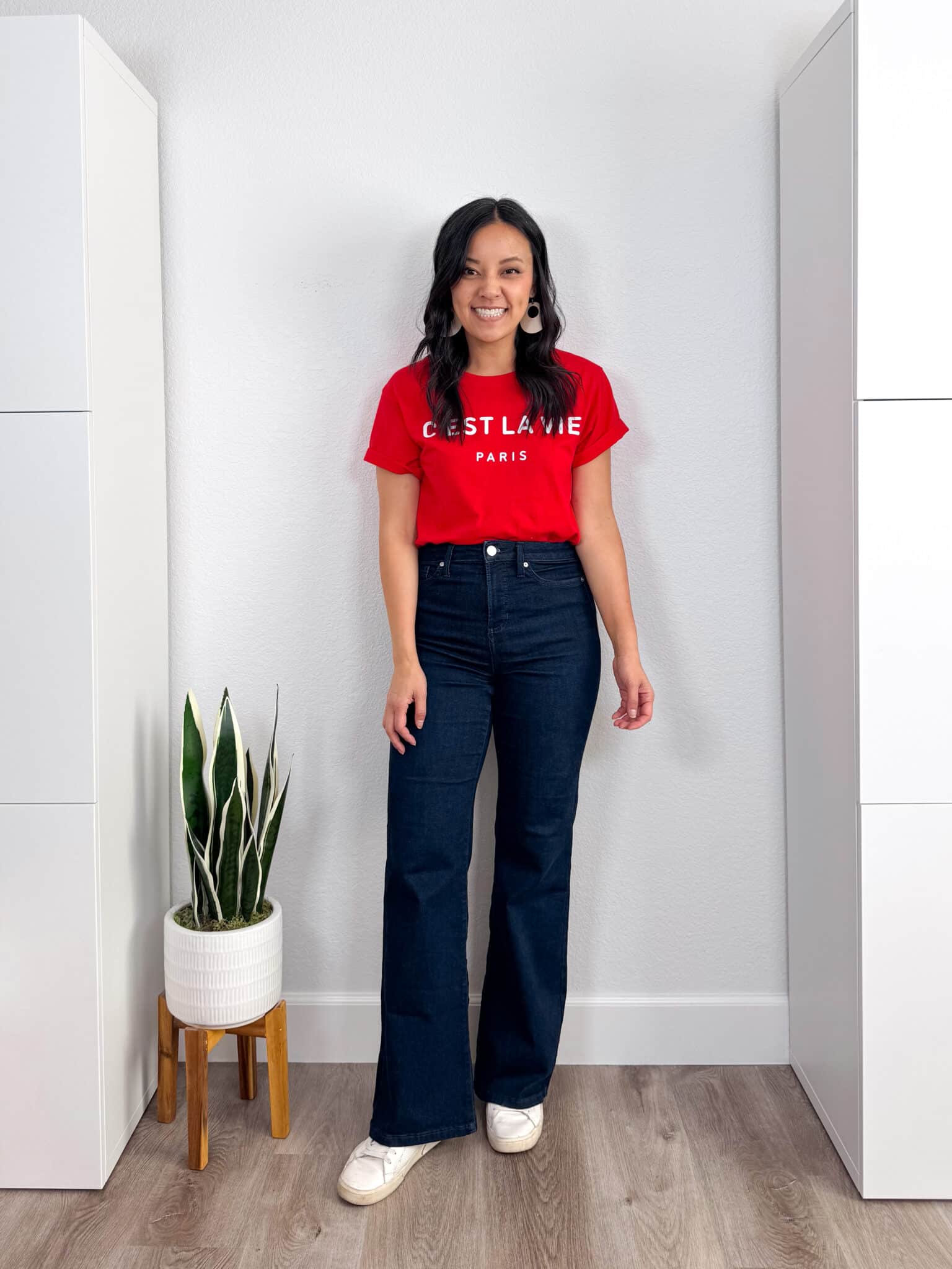 casual outfit with flare jeans: red Paris tee, dark wash flare jeans, white lifestyle sneakers