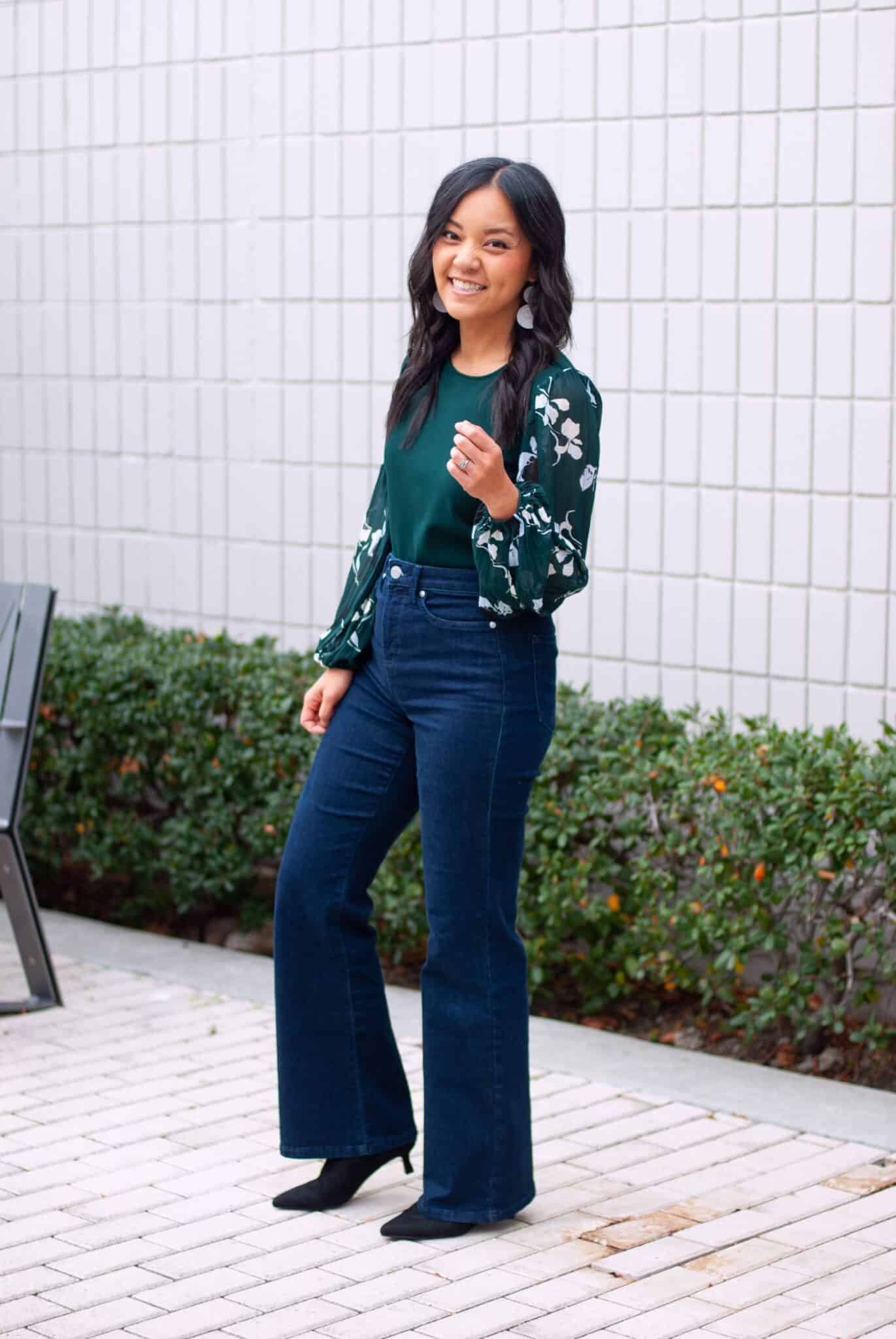 Dressy Casual Holiday Outfit Green Blouse Dark Wash Flare Jeans Black Pointed Toe Boots Side View