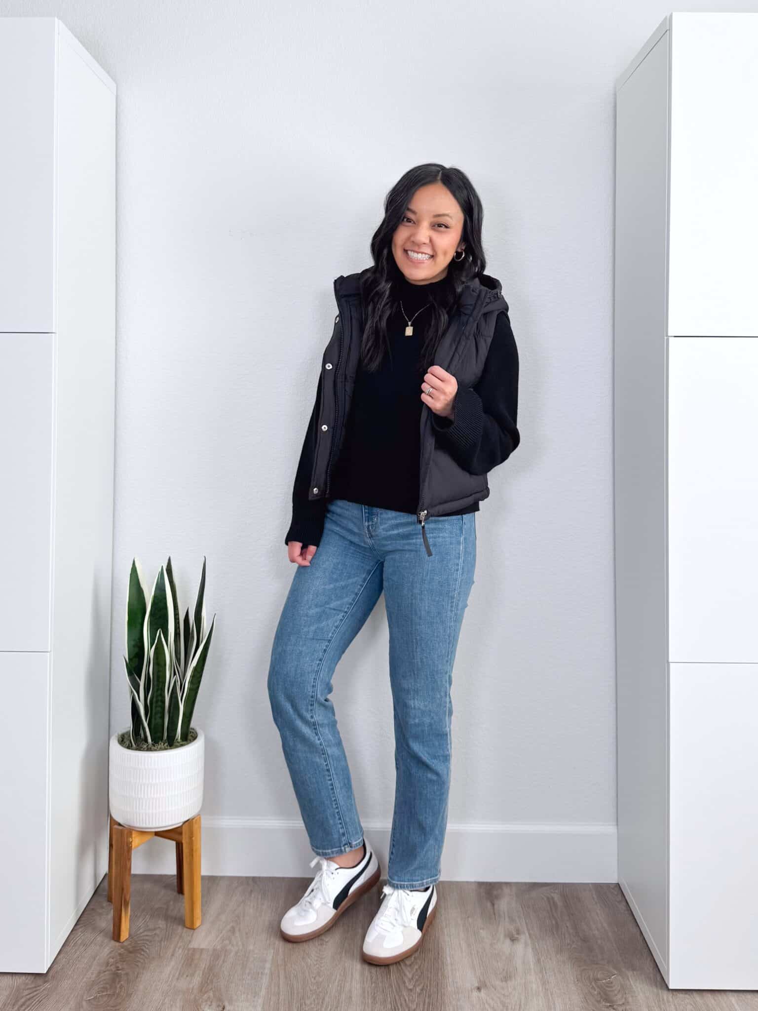 black sweater outfit ideas + putting me together + 10 Black Sweater Outfit Ideas You Can Easily Copy for Winter + versatile black sweater + cozy black puffer vest + comfortable medium wash straight leg jeans + black hooded vest + black and white sneakers