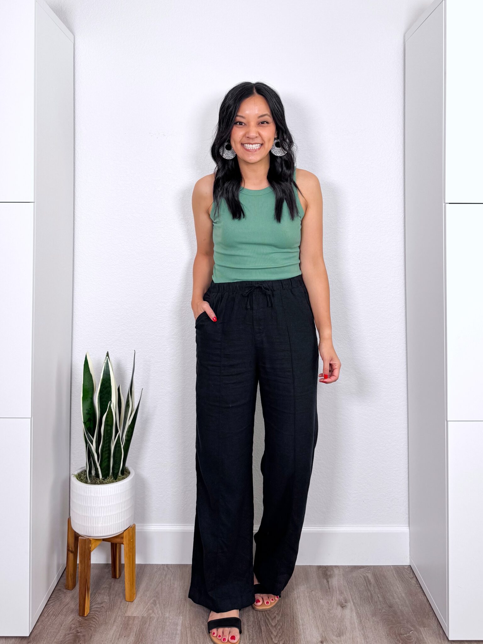 What to Wear With Black Linen Pants: 14 Outfit Ideas for Summer You Can Easily Copy + black linen pants outfit + putting me together + versatile green tank + black wide leg linen pants + black sandals + lightweight leopard print earrings