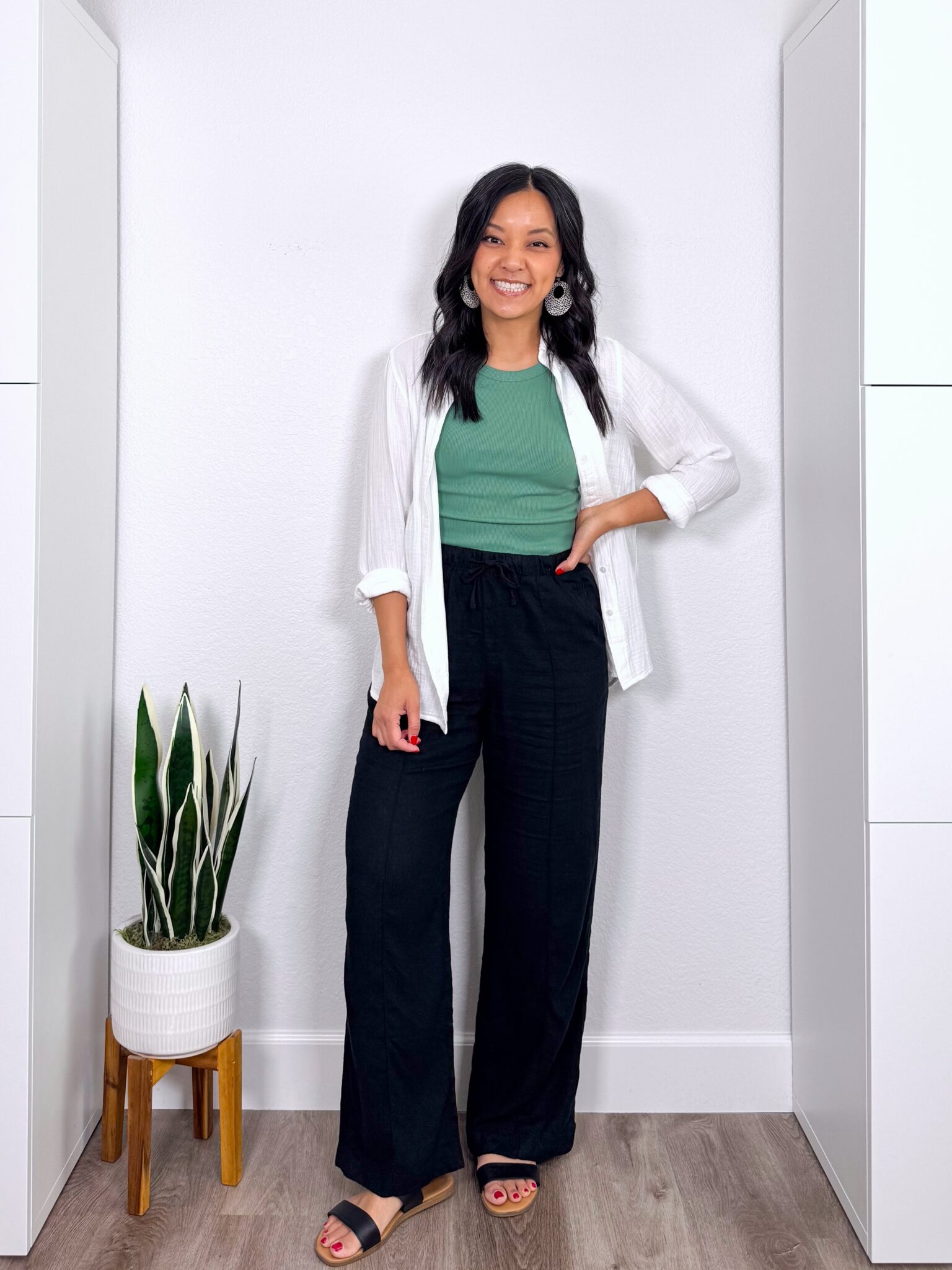 What to Wear With Black Linen Pants: 14 Outfit Ideas for Summer You Can Easily Copy + black linen pants outfit + putting me together + versatile green tank + black wide leg linen pants + lightweight white gauze button up shirt + black sandals + lightweight leopard print earrings