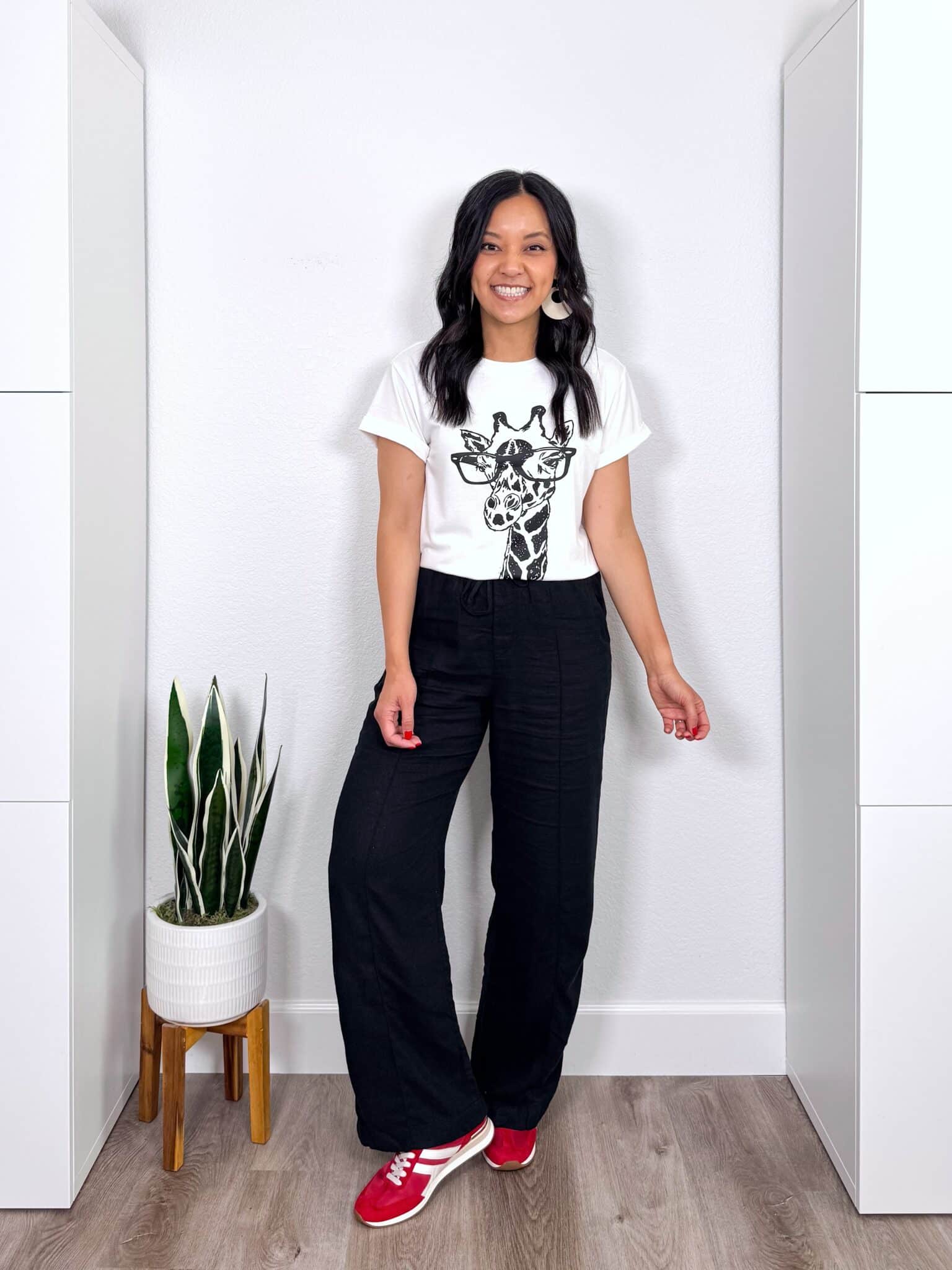 What to Wear With Black Linen Pants: 14 Outfit Ideas for Summer You Can Easily Copy + black linen pants outfit + putting me together + black and white giraffe graphic tee + black wide leg linen pants + fun red sneakers + lightweight white earrings