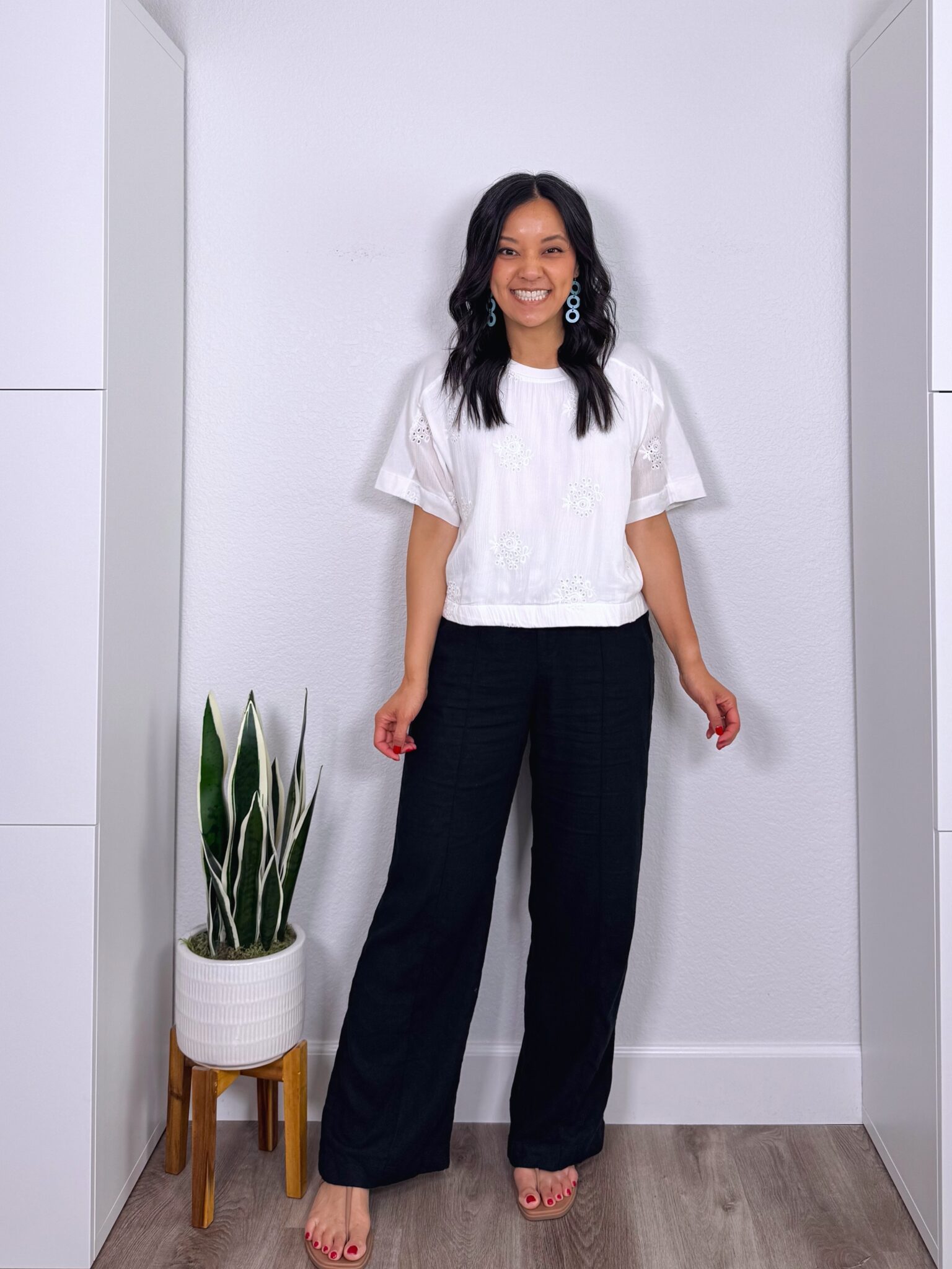 What to Wear With Black Linen Pants: 14 Outfit Ideas for Summer You Can Easily Copy + black linen pants outfit + putting me together + white top with eyelet embroidery + black wide leg linen pants + comfortable water friendly tan sandals + lightweight teal earrings