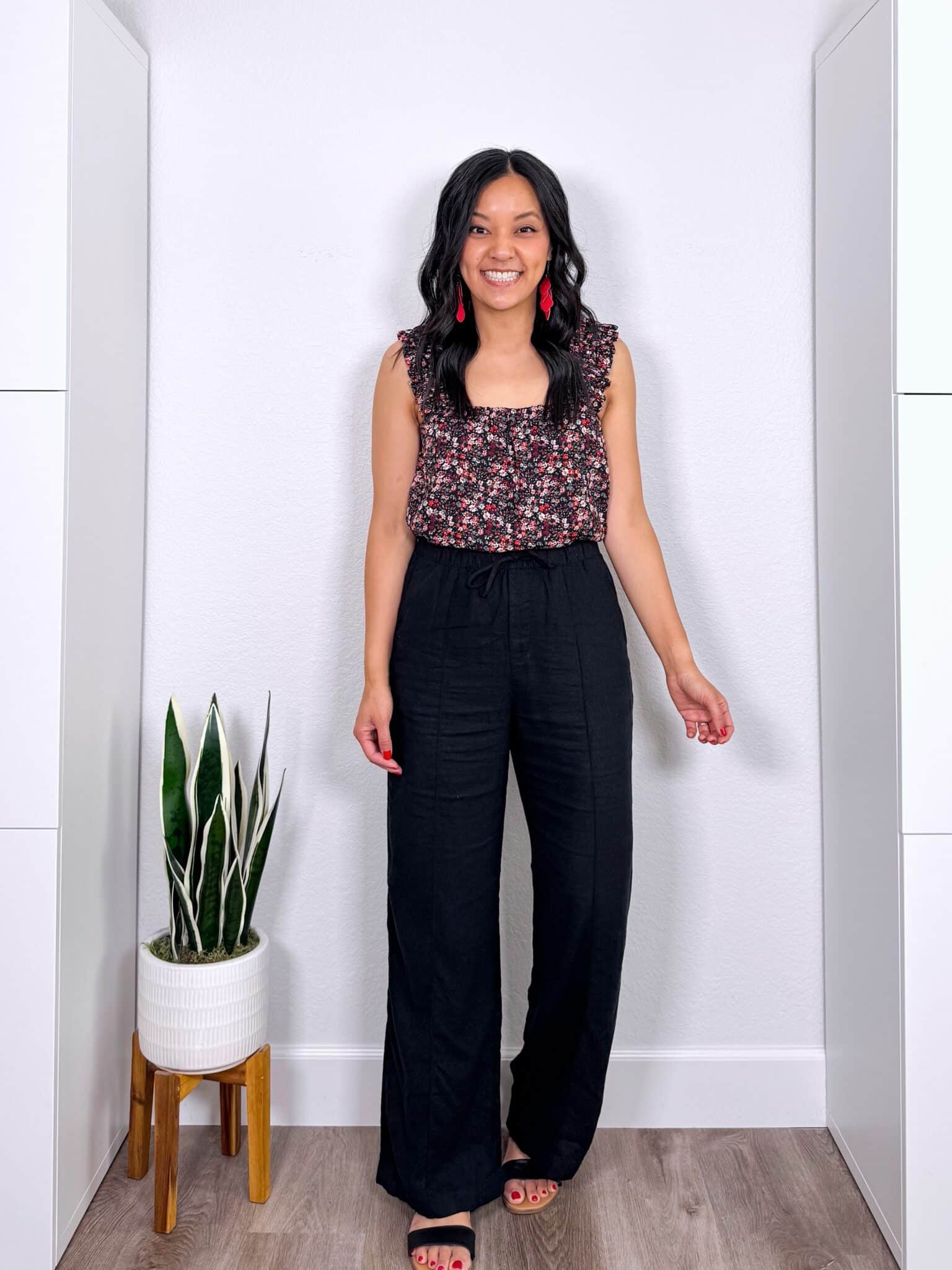 What to Wear With Black Linen Pants: 14 Outfit Ideas for Summer You Can Easily Copy + black linen pants outfit + putting me together + pretty red, white, pink, green and black flowered tank + black wide leg linen pants + lightweight denim jacket + black sandals + red earrings